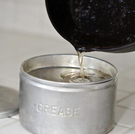 Photo: pouring grease into an aluminum can