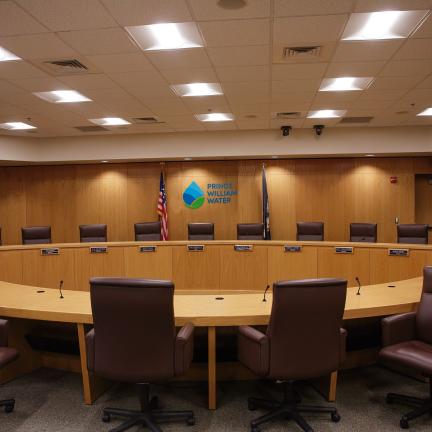 Photo: a board room with a water drop logo and Prince William Water signage on the wall.