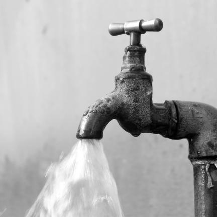 Photo: an old lead water faucet with the water turned on