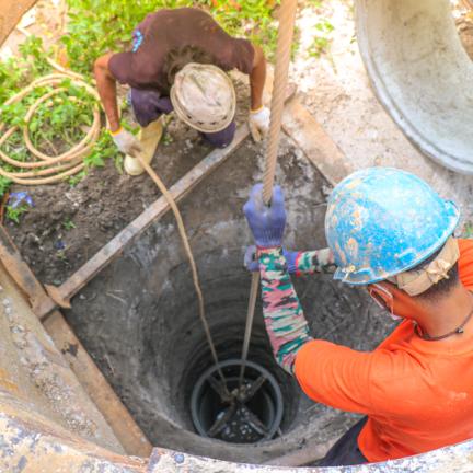 Workers installing a well