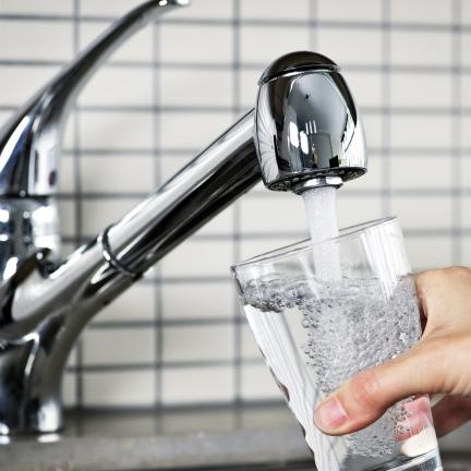 Photo: someone filling a glass of water from the tap