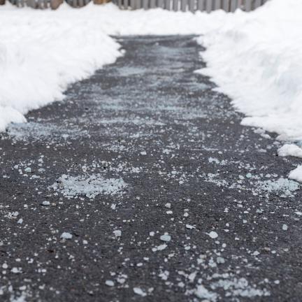 Road salt on an icy pavement pathway