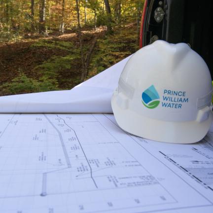 A hard hat on top of a set of paper building plans