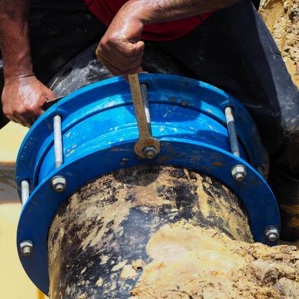 A utility employee repairing a water main break