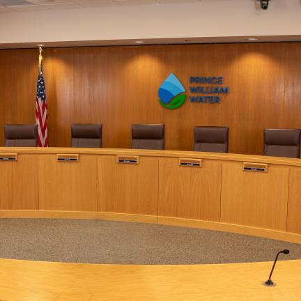 Prince William Water's Board of Directors meeting room with yellow oak paneling and a Prince William Water logo