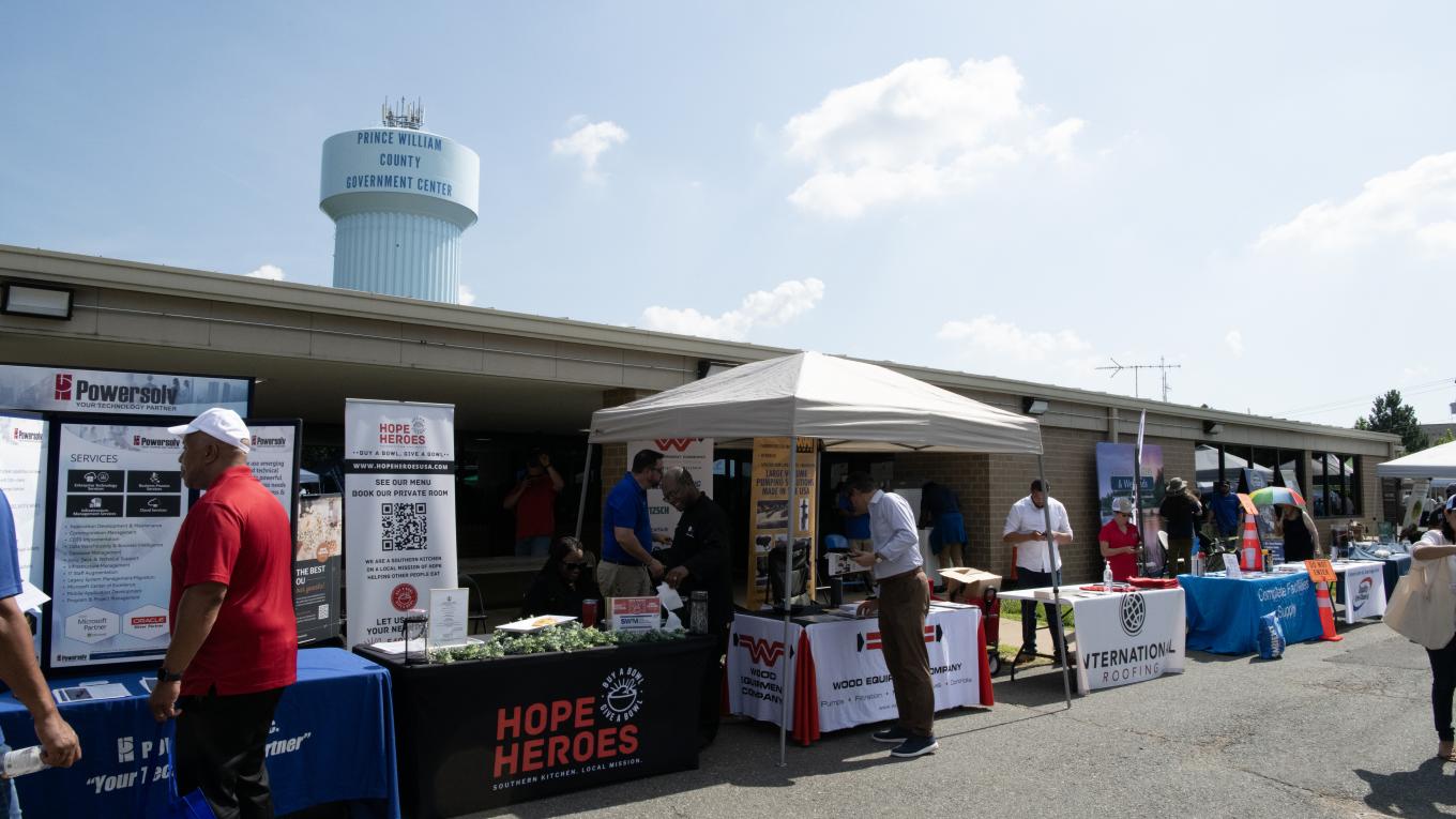 Photo: people gather at tables at a vendor expo