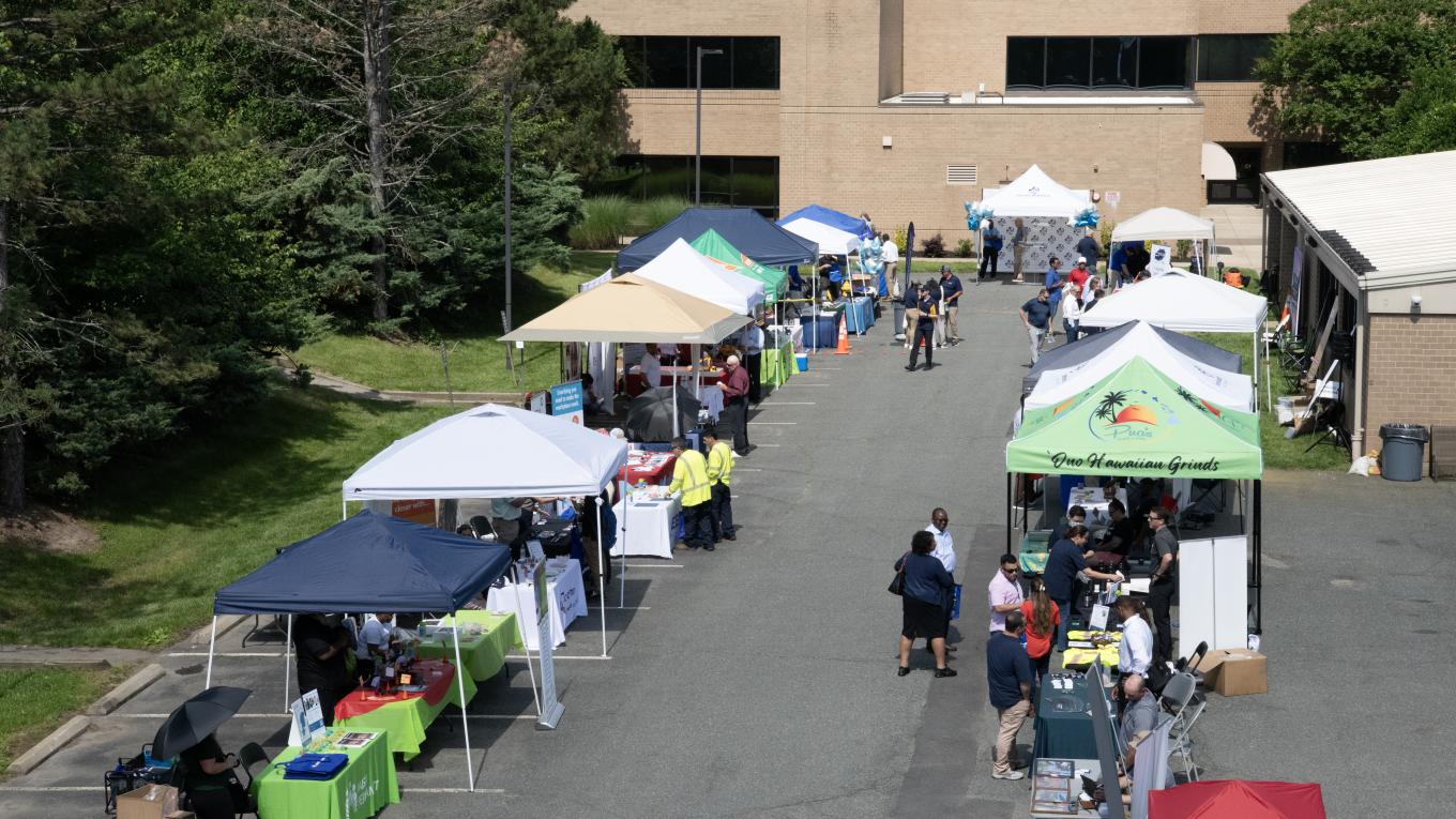 Photo: aerial view of people mingling among tents and tables at a vendor expo