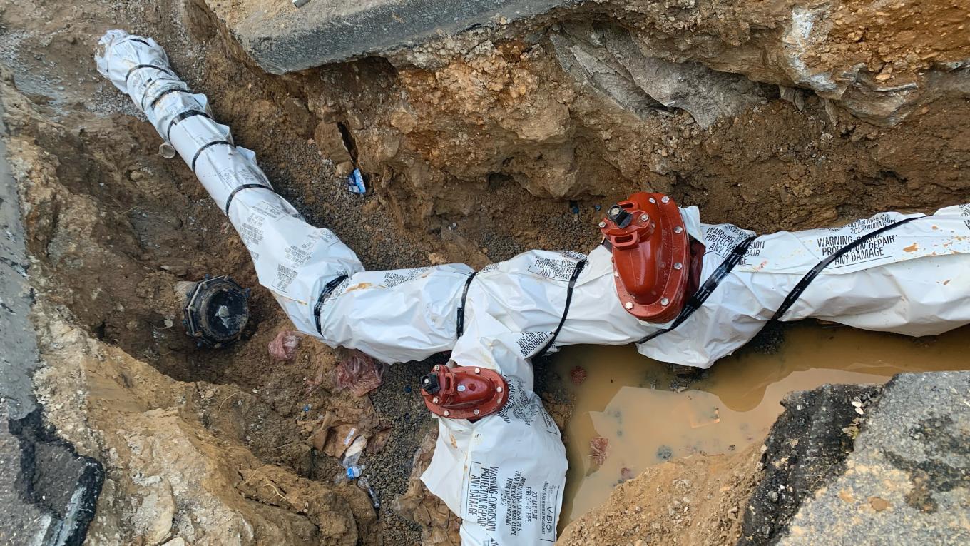 An underground pipe wrapped in plastic