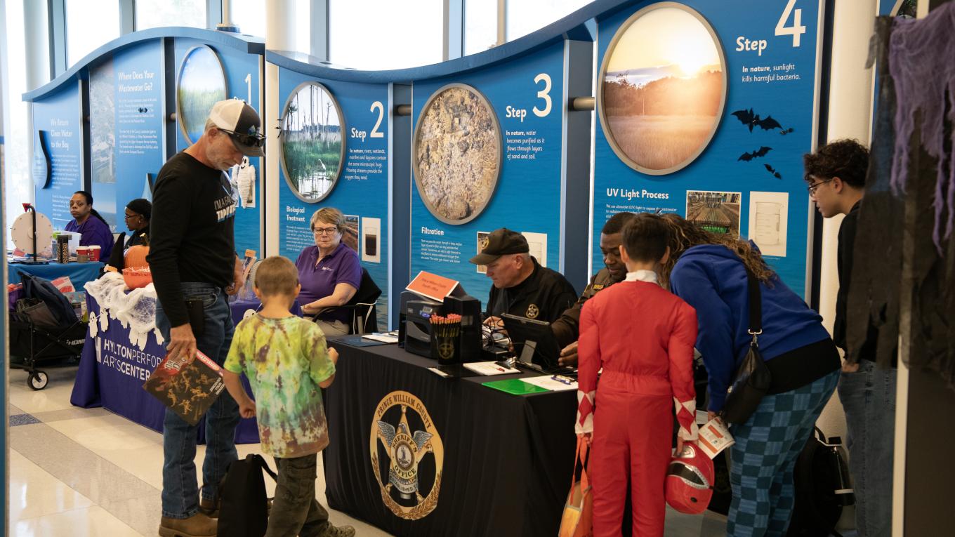 Individuals line up at tables at a Halloween themed event