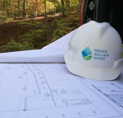 A hard hat on top of a set of paper building plans