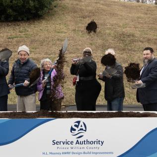 Photo: individuals tossing dirt with shovels at a groundbreaking ceremony
