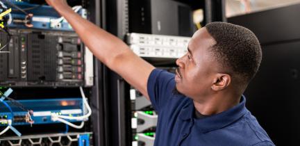 Photo: a man fixing servers in a server room