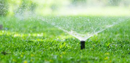 Photo: an automatic sprinkler irrigating grass