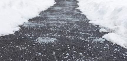Road salt on an icy pavement pathway