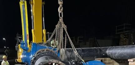 A large valve is lowered using a crane