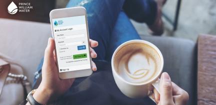 A person drinking a coffee holding a phone in their lap. The phone displays the Prince William Water mobile app. 