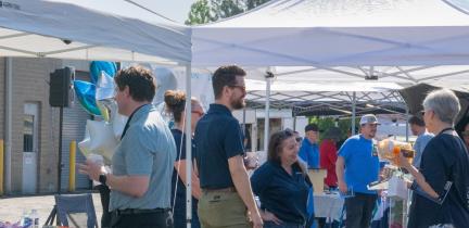 Individuals standing outside near displays on a sunny day at the Supplier Diversity Expo on May 19, 2026 