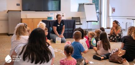 Children listening to a presenter while sitting on the floor at a library