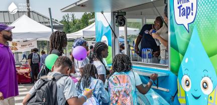 Children gather around a water-dispensing concession vehicle during Prince William County Schools' Back to School event