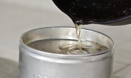 Photo: pouring grease into an aluminum can