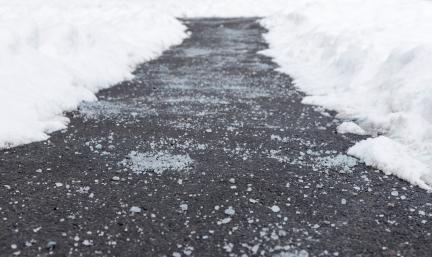 Road salt on an icy pavement pathway