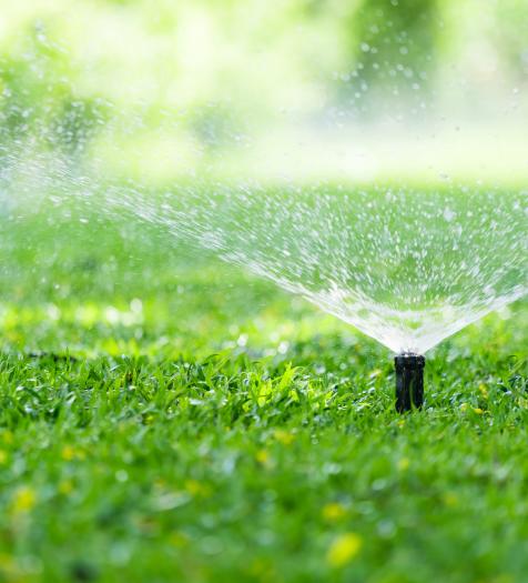 Photo: an automatic sprinkler irrigating grass