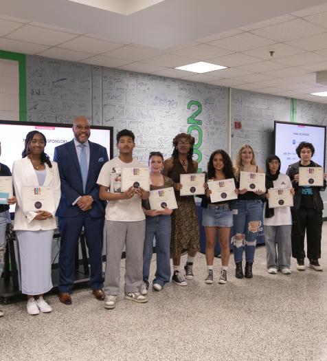 A group of high school students holding certificates