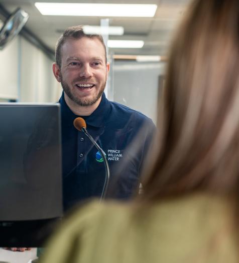 A customer service representative assists a customer at a customer service window